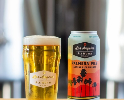 Palmera Pils beer in glass next to can