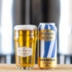 Superstein beer in glass next to gold, white and blue can