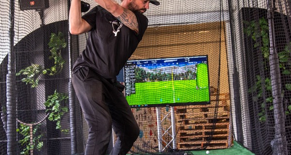 Man swinging a golf club in a Virtual Golf setup
