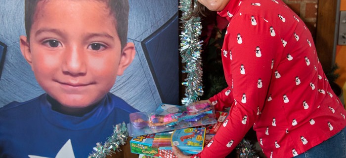 Woman donating a toy to a toy drive box