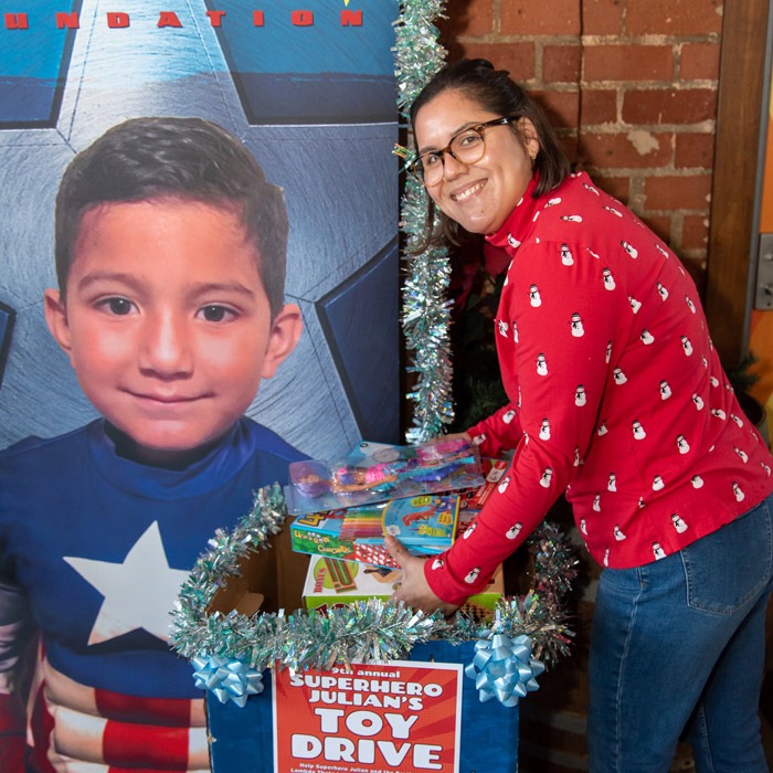 Woman donating a toy to a toy drive box